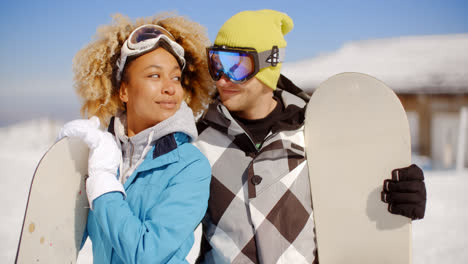 Affectionate-young-couple-posing-with-snowboards