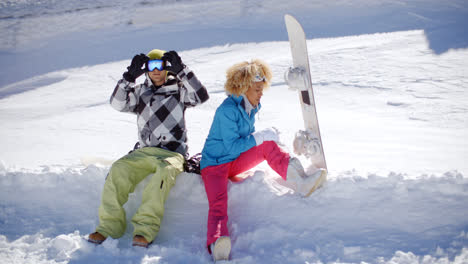 Young-couple-getting-ready-to-go-snowboarding
