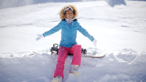 Schöne-Junge-Snowboarderin-Sitzt-Auf-Schnee