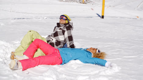 Couple-resting-on-hill-after-skiing