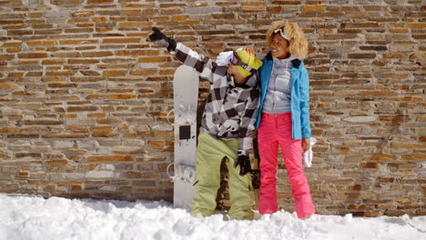 Snowboarder-with-happy-friend-pointing-upwards