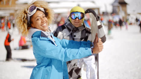 Man-flirting-with-woman-holding-snowboard
