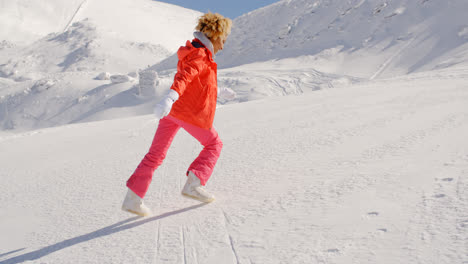 Person-in-snowsuit-running-up-mountain