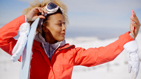Young-woman-taking-her-selfie-with-a-snowboard