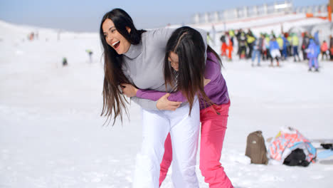 Two-playful-woman-frolicking-in-the-snow