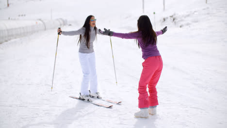 Young-woman-teaching-her-friend-to-ski