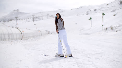 Cute-woman-on-skis-at-bottom-of-hill