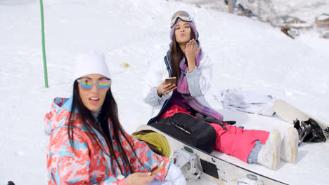 Dos-Mujeres-Atractivas-Practicantes-De-Snowboard-Relajándose