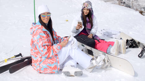 Two-attractive-women-snowboarders-relaxing