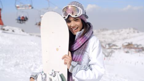 Lachende-Junge-Frau-Mit-Ihrem-Snowboard