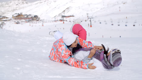 Two-young-woman-enjoying-a-frolic-in-the-snow