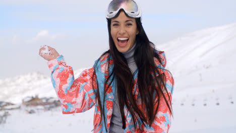 Laughing-young-woman-throwing-a-snowball