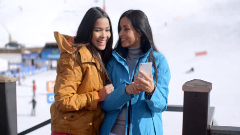 Two-smiling-young-women-checking-a-phone