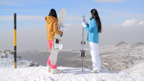 Two-women-snowboarders-enjoying-the-winter-view