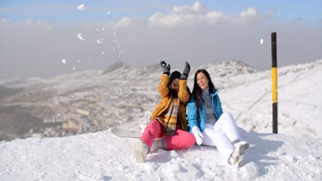 Two-young-women-having-fun-in-winter-snow