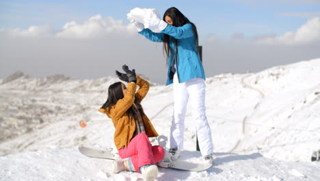 Two-young-female-friends-playing-in-the-snow