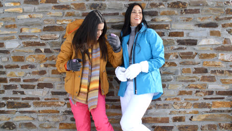 Cute-twins-in-winter-coats-leaning-on-wall