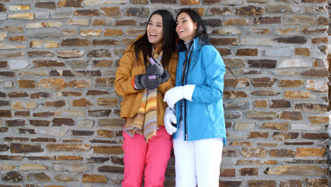Cute-twins-in-winter-coats-leaning-on-wall