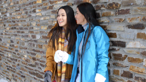 Laughing-twins-in-jackets-and-glove-near-wall