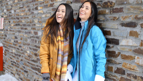 Laughing-twins-in-jackets-and-glove-near-wall