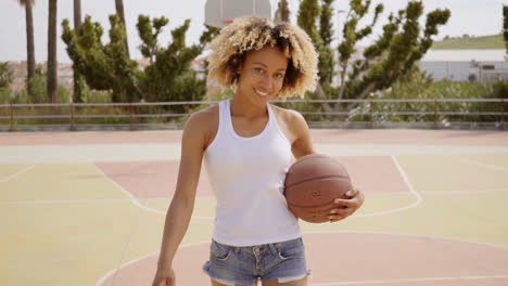 Sporty-young-woman-with-a-baseball-on-a-court