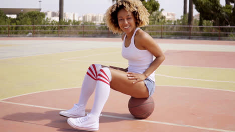 Blond-young-woman-sits-cross-legged-on-ball