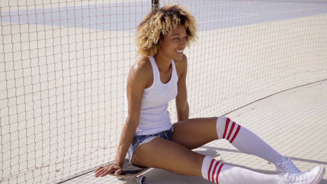 Young-skater-relaxes-beside-tennis-court