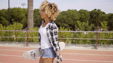 One-young-female-skater-walking-with-board-in-hand