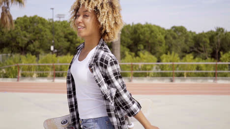 One-young-female-skater-walking-with-board-in-hand