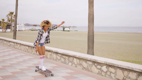 Young-woman-skateboarding-at-the-seafront