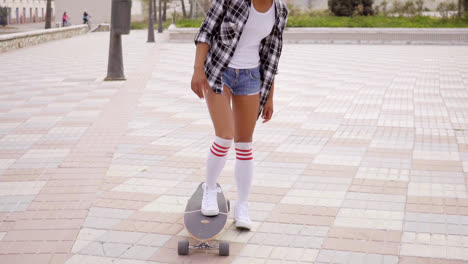 Unidentifiable-woman-stepping-on-skateboard