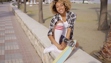Süßer-Teenager-Sitzt-Auf-Felsvorsprung-Mit-Skateboard