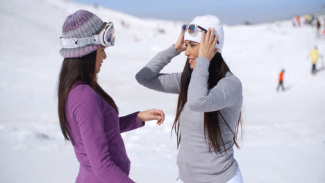 Two-stylish-young-woman-chatting-at-a-ski-resort