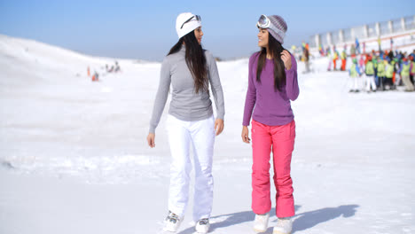 Dos-Mujeres-Jóvenes-Atractivas-Caminando-En-La-Nieve-Fresca