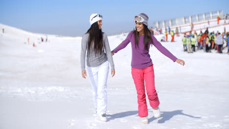 Two-attractive-young-woman-walking-in-fresh-snow