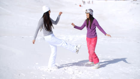 Two-young-woman-frolicking-in-winter-snow