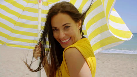 Flirtatious-young-woman-holding-a-beach-umbrella