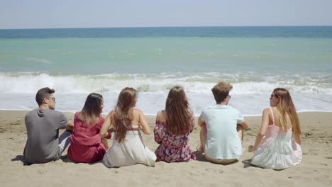 Sechs-Junge-Leute-Sitzen-Mit-Blick-Auf-Den-Ozean