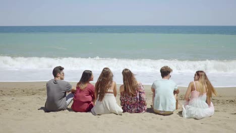 Six-young-people-sitting-overlooking-the-ocean
