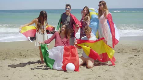 Group-of-Friends-on-Beach-with-Football-and-Flags