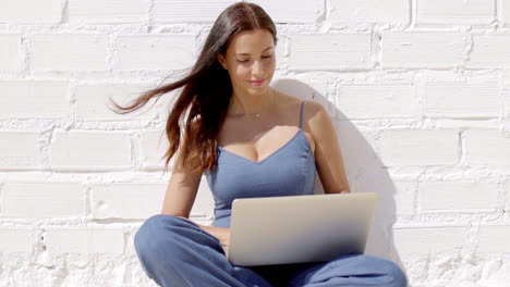 Young-woman-working-on-a-laptop-in-the-sunshine