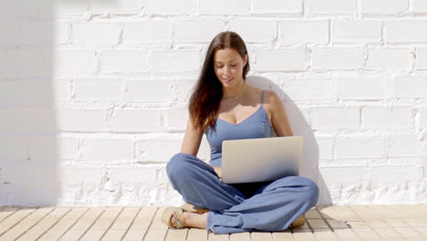 Young-woman-working-on-a-laptop-in-the-sunshine