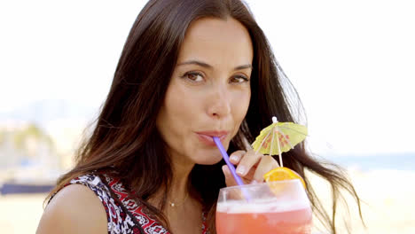 Pretty-woman-sipping-a-cocktail-at-the-beach