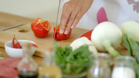 Housewife-chopping-a-fresh-red-bell-pepper