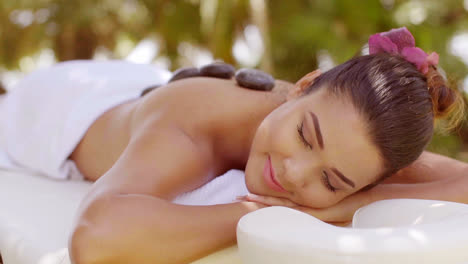 Blissful-young-woman-having-a-hot-stone-massage