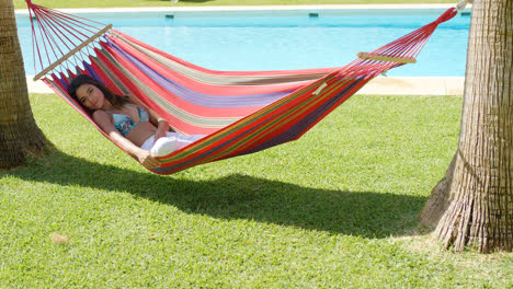 Relaxing-young-woman-in-colorful-hammock