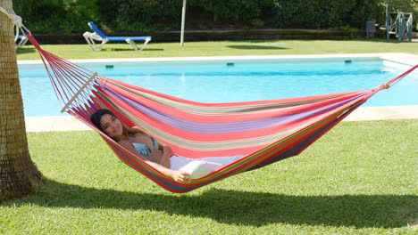 Woman-in-hammock-at-tropic-resort-with-pool