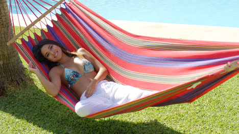 Smiling-young-woman-laying-down-in-hammock