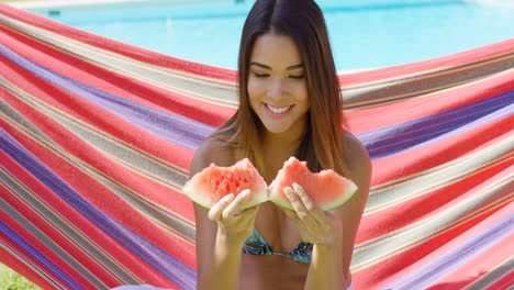Smiling-young-woman-holding-one-watermelon-slice