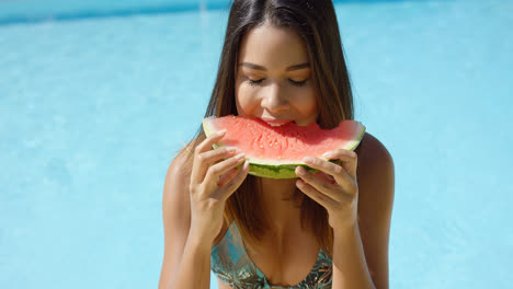 Glückliche-Frau-Am-Rand-Des-Pools,-Die-Wassermelone-Isst